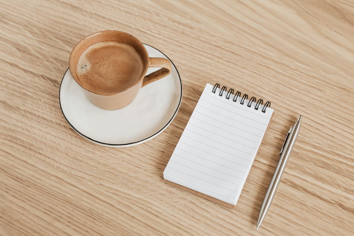 コーヒーとノートを置いた机。考えを整理するためのひととき